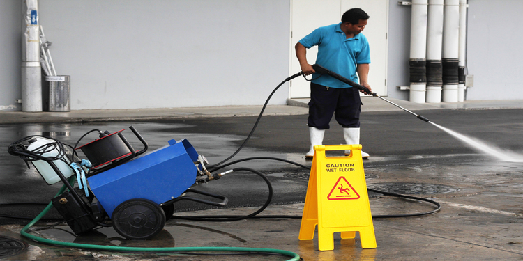 worker cleaning floor with air high pressure machine